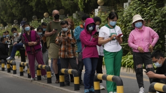 Residents wearing masks line up for mass COVID testing in Beijing.