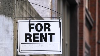 A "For Rent" sign is posted on a building