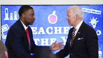 President Joe Biden shakes hands with 2022 National Teacher of the Year Kurt Russell.
