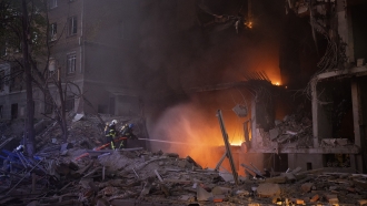Firefighters try to put out a fire following an explosion in Kyiv, Ukraine