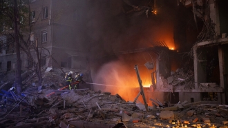 Firefighters try to put out a fire following an explosion in Kyiv, Ukraine.