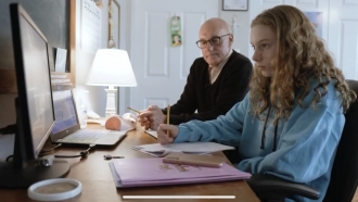 Caroline Dickinson gets help with schoolwork from her father