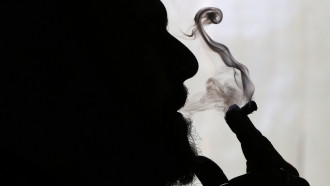 A man smokes medical marijuana at his home.