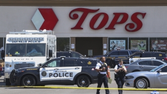 Police walk outside the Tops grocery store.