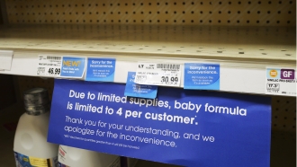 A limited supply sign is shown on the baby formula shelf at a grocery store