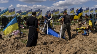 Undertakers lower the coffin of a Ukrainian serviceman