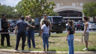 Law enforcement officers with people outside Uvalde High School
