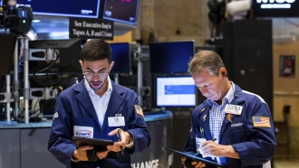 Two men work on the floor of the New York Stock Exchange.