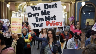Woman holding a sign at a protest against abortion bans