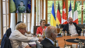 G7 leaders before a round table as Ukraine President Volodymyr Zelenskyy appears on screen to address them