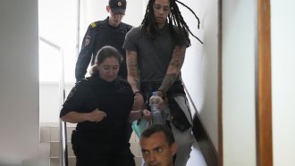 WNBA star Brittney Griner is escorted into a courtroom for a hearing
