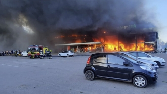 Firefighters work to extinguish a fire at a shopping center burned after a rocket attack in Ukraine