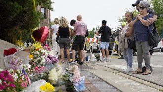 People visit a memorial to those killed and wounded in a mass shooting in Highland Park, Illinois.