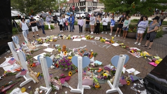 Residents visit a memorial to the seven people who lost their lives in the Highland Park, Illinois, mass shooting