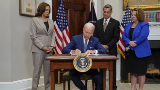 President Joe Biden signs an executive order on abortion access during an event in the Roosevelt Room of the White House.
