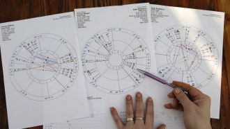 An astrologer works on star charts.