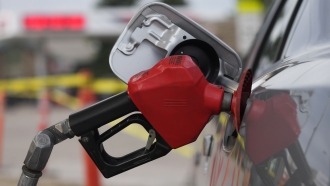 Gasoline nozzle being used to pump gas.