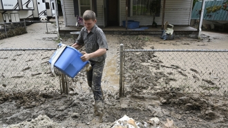 Man cleans up debris from homes following flooding in Kentucky.