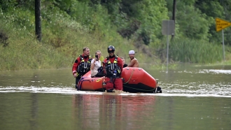 Members of the Winchester, Kentucky, Fire Department rescue people with inflatable boats in floodwater