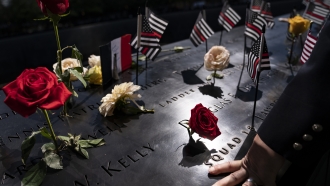 A firefighter places his hand on name engravings to commemorate the lives lost during the terrorist attacks on Sept. 11, 2001
