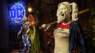 A Harley Quinn statue is displayed.