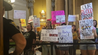 Abortion-rights protesters fill Indiana Statehouse corridors and cheer outside legislative chambers.