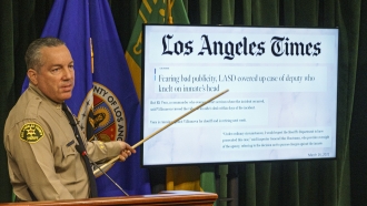 Los Angeles County Sheriff Alex Villanueva points to a Los Angeles Times story during a news conference.