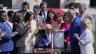 President Joe Biden holds the "CHIPS and Science Act of 2022" after signing it