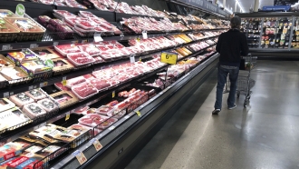 a shopper pushes his cart past a display of packaged meat in a grocery store in southeast Denver