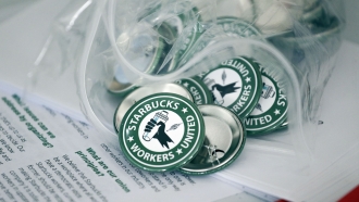 Pro-union pins sit on a table during a watch party for Starbucks' employees union election