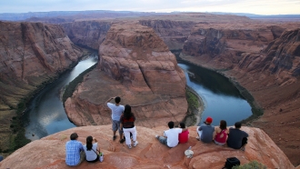 Visitors view the dramatic bend in the Colorado River at the popular Horseshoe Bend in Glen Canyon National Recreation Area