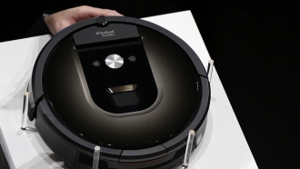 A Roomba 980 vacuum cleaning robot is shown during a presentation