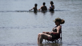 A woman sits in cooling water in California.