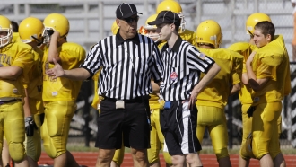 Referees talk on a field.