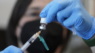 A nurse prepares a vaccine dose.