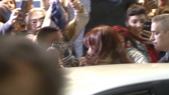 Still image taken from a video shows a man pointing a gun at Argentina's Vice President Cristina Fernandez.