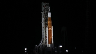 NASA's new moon rocket is illuminated by xenon lights as she sits on Launch Pad 39-B hours ahead of a planned launch.