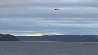 U.S. Coast Guard helicopter surveying waters.