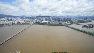 The Han River, swollen with floodwater, flows under bridges in Seoul, South Korea.