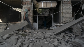 A man walks over debris of a psychiatric hospital that was heavily damaged after a Russian attack.