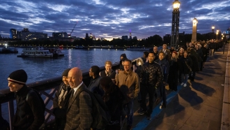 People stand in a queue to pay their respects to the late Queen Elizabeth II.