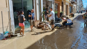 People clean up debris from flooding in Italy.