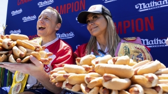 Joey Chestnut and Miki Sudo pose with 63 and 40 hot dogs