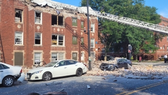 Firefighters assess an apartment in Chicago after an explosion