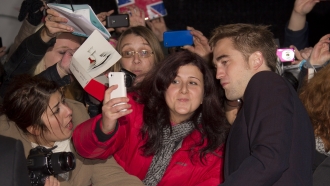 Robert Pattinson, who plays Edward Cullen, poses with fans as he arrives for the European Premiere of The Twilight Saga