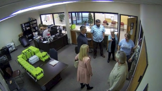 Security video appears to show Cathy Latham (center, long turquoise top), introducing members of a computer forensic team.