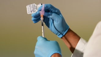 A registered nurse prepares a dose of the Pfizer COVID-19 vaccine for children