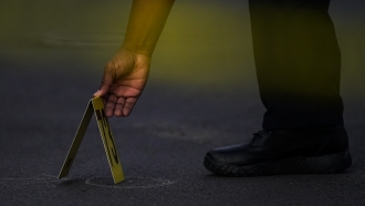 A police officer places an evidence marker.