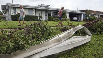 A couple clears their yard of debris in Hollywood, Florida.