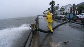 A worker moves a sandbag after a pump was placed to remove water from the Battery as the effects from Hurricane Ian are felt